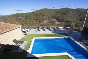 a swimming pool on the side of a house at Vila Caelus masía boutique in Rubio