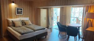 1 dormitorio con 1 cama y 1 mesa con sillas en Apartamenty Leśna Przystań en Węgorzewo