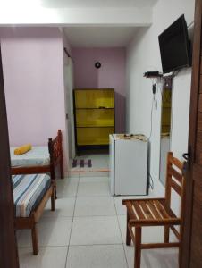 a room with two chairs and a refrigerator at Pousada dos Ventos in Pôrto de Pedras