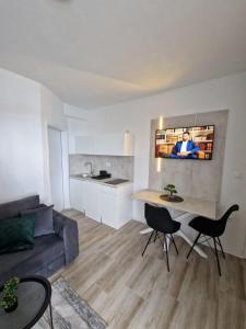 ein Wohnzimmer mit einem Sofa, einem Tisch und Stühlen in der Unterkunft Elegance Dream Apartment in Neum