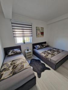 1 Schlafzimmer mit 2 Betten und einem Fenster in der Unterkunft Elegance Dream Apartment in Neum