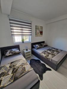 une chambre avec deux lits et une fenêtre dans l'établissement Elegance Dream Apartment, à Neum