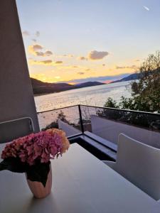 eine Vase mit Blumen auf einem Tisch auf einem Balkon in der Unterkunft Elegance Dream Apartment in Neum