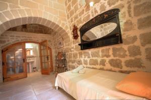 ein Schlafzimmer mit einem Bett und einer Steinmauer in der Unterkunft Dar Is-Sultan Farmhouse in Il-Wilġa