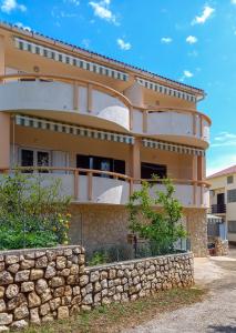 a house with a stone wall in front of it at Apartments MULOBEDANJ in Lun