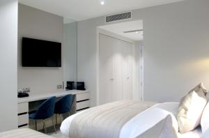 a bedroom with a bed and a desk and a tv at NOX Richmond in Richmond