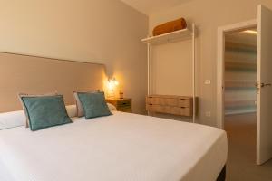 1 dormitorio con 1 cama blanca grande con almohadas azules en A Oliveira, en Vilaboa