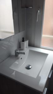 um lavatório branco na casa de banho com um espelho em Apartamento Aitue em Gijón