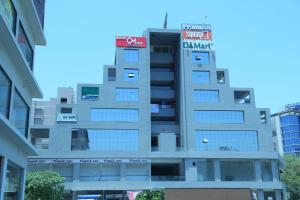 un edificio alto con un cartel encima en HOTEL OM INN, en Gandhinagar