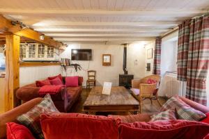 ein Wohnzimmer mit Sofas und einem Tisch in der Unterkunft Cottage des Pléiades - Station de ski accessible à pieds in Les Angles