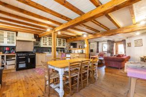 Cottage des Pléiades - Station de ski accessible à pieds في ليز أنغلز: مطبخ وغرفة طعام مع طاولة وكراسي