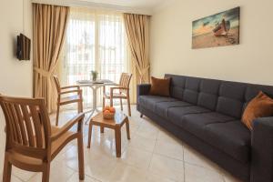 a living room with a couch and a table at Liman Apart Hotel in Marmaris
