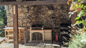 a stone wall with a grill in a yard at La Grange de Cassiopée - Duplex avec vue imprenable in Les Angles