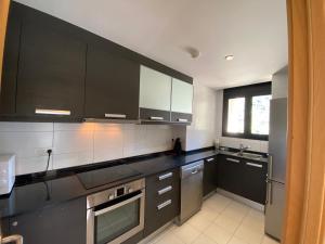 a kitchen with black and white cabinets and a sink at Canillo L'Areny View in Canillo