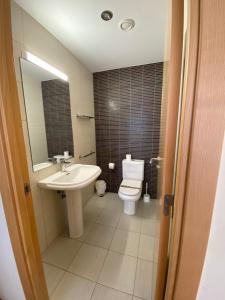 ein Badezimmer mit einem Waschbecken, einem WC und einem Spiegel in der Unterkunft Canillo L'Areny View in Canillo