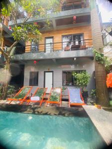ニンビンにあるAsahi Villa Tam Cocのスイミングプール、椅子、建物を併設するリゾートです。