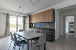 a kitchen and dining room with a table and chairs at Condominio Trento in Lido di Jesolo