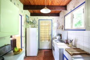 une cuisine avec un réfrigérateur blanc et une fenêtre dans l'établissement La Cerisaie, maison spacieuse en Lubéron, à Saint-Martin-de-Castillon