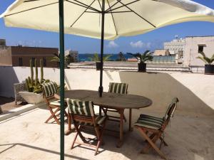 a table and chairs under an umbrella on a roof at Alla Busiata in Trapani