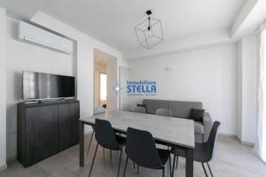 a dining room with a table and chairs and a television at Condominio Trento in Lido di Jesolo