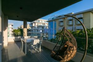 a balcony with a table and a swing at Condominio Trento in Lido di Jesolo