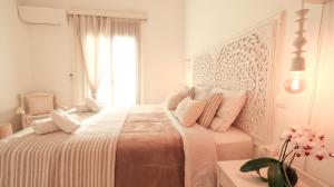 Biała sypialnia z dużym łóżkiem i różowymi poduszkami w obiekcie Comfortable Apartment with Garden - Casa con Vista w mieście Chavania