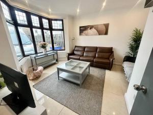 a living room with a couch and a table at 5 bedroom House SE6 in Hither Green
