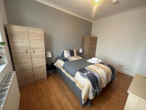 Un dormitorio con una cama grande y una cómoda. en 5 bedroom House SE6, en Hither Green