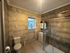 baño con aseo y ducha y ventana en 5 bedroom House SE6, en Hither Green 25 fotos más