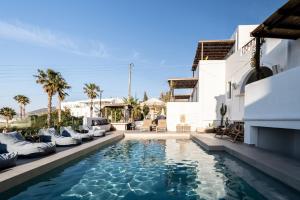 a swimming pool with lounge chairs next to a house at PAREA Paros - Adults Only in Kampos Paros