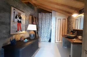 a hallway with a table and a lamp in a room at Casa dos Gatos in Calheta
