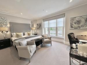 a bedroom with a bed and a desk and chairs at Tavistock House Hotel in Tavistock