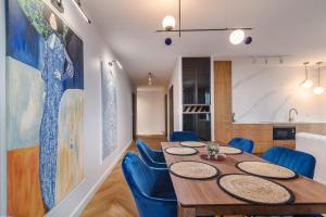 a dining room with a table and blue chairs at Comfort Apartments 10 lutego in Gdynia