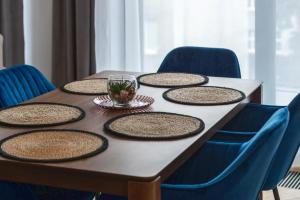 a table with nine plates on it with blue chairs at Comfort Apartments 10 lutego in Gdynia