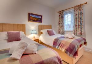 - une chambre avec 2 lits et une fenêtre dans l'établissement Creamery Cottage, à Whitby