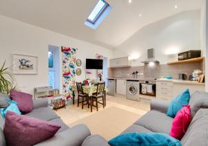 a living room with two couches and a kitchen at Cowtons Old Dairy in East Cowton