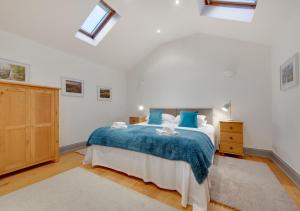 - une chambre avec un grand lit et une couverture bleue dans l'établissement Cowtons Old Dairy, à East Cowton