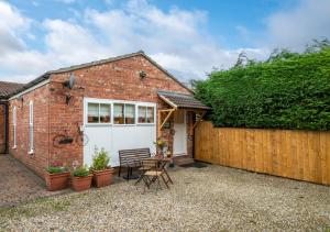 a brick house with a white garage and a fence at Cowtons Old Dairy in East Cowton