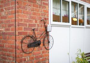 un vélo suspendu sur un mur de briques à côté d'une porte dans l'établissement Cowtons Old Dairy, à East Cowton