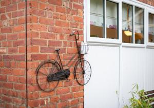 a bike hanging on a brick wall next to a door at Cowtons Old Dairy in East Cowton