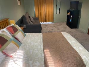 a bedroom with a large bed and a couch at Kings Arms in Llandysul +2 photos