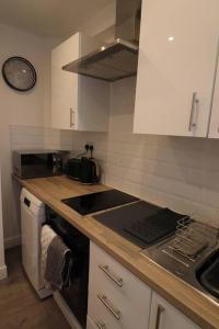 a kitchen with a sink and a stove top oven at Stylish one bed apartment with off road parking in Birmingham