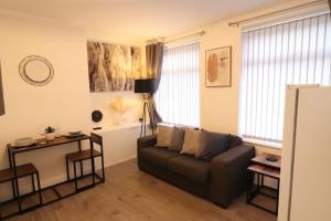 a living room with a couch and a table at Stylish one bed apartment with off road parking in Birmingham