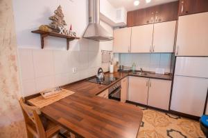 a kitchen with a wooden table and a refrigerator at Apart-Invest Apartament Hajduczek in Szklarska Poręba
