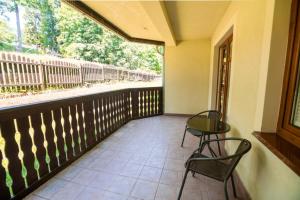 a balcony with two chairs and a table and a window at Apart-Invest Apartament Hajduczek in Szklarska Poręba