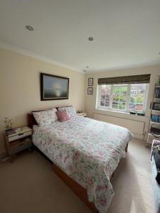a bedroom with a large bed and a window at Beautiful 4BD House with Large Garden - Kingston in New Malden