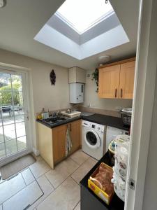 a kitchen with a sink and a washer and dryer at Beautiful 4BD House with Large Garden - Kingston in New Malden
