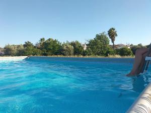 欧里基Refúgio na Aldeia的坐在游泳池椅子上的人