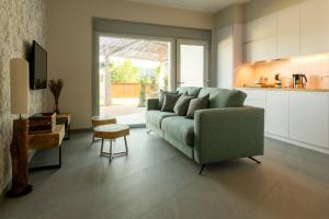 sala de estar con sofá verde y cocina en A Oliveira, en Vilaboa