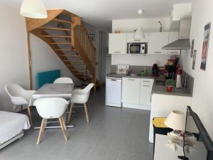 a kitchen and dining room with a table and chairs at Charmante maisonnette à Quend Plage, 2 chambres, jardinet, parking, proche commodités - FR-1-482-45 in Quend